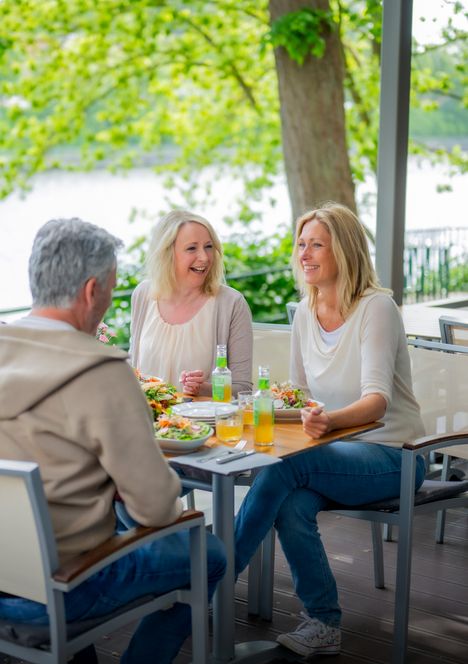 Drei Personen sitzen am Tisch und essen zu Mittag