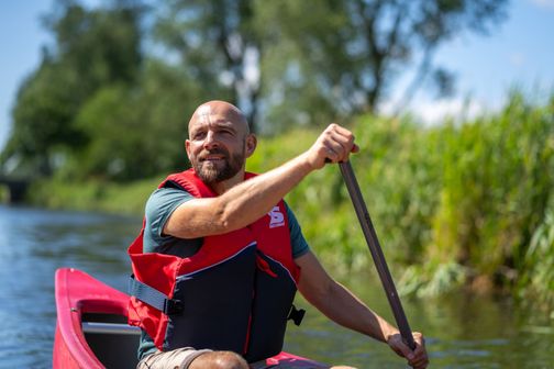 Ein Mann im Kanu auf einem Fluss
