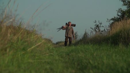 Mann mit Kamera in Natur unterwegs