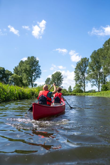 Zwei Personen im Kanu paddeln auf einem Fluss
