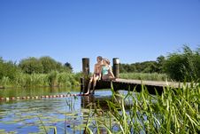 Ein Pärchen sitzt auf dem Badesteg