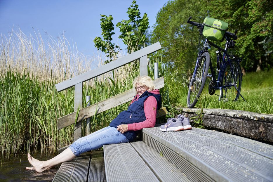 Frau macht Pause am Wasser
