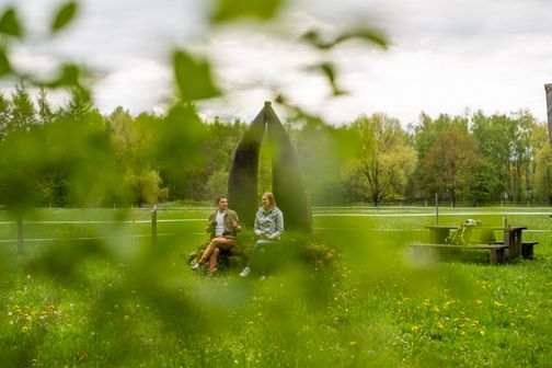 Pärchen sitzt vor Ochsenweg-Denkmal