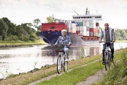 Radfahren am Nord-Ostsee-Kanal mit Schiff im Hintergrund