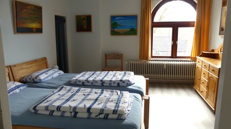 Zwei zusammenstehende Betten, Kommode, Durchgang zum 2. Schlafzimmer