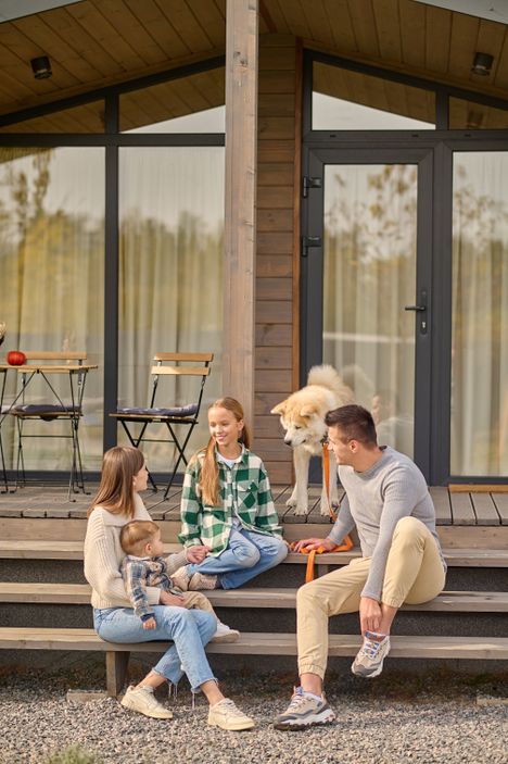 Familie sitzt auf der Terrasse eines Hauses