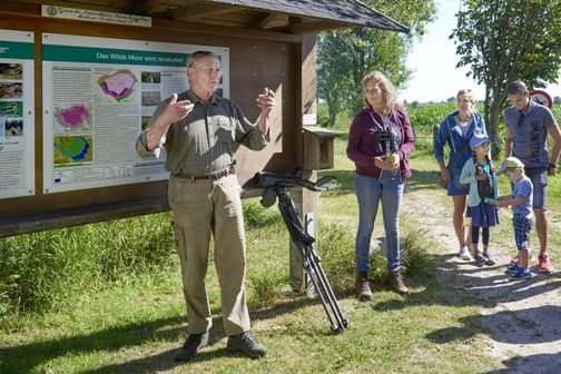 Wanderführer erklärt einer Gruppe etwas