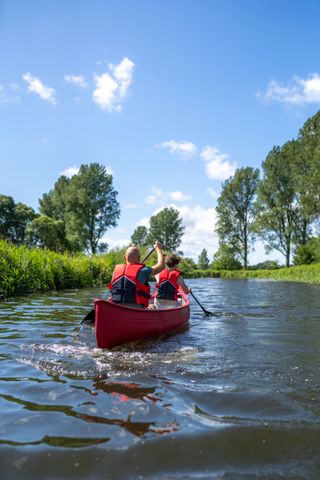 Zwei Personen im Kanu paddeln auf einem Fluss