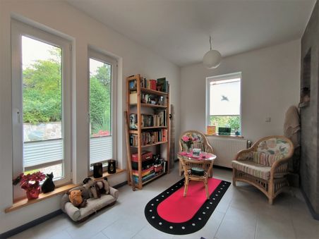 Zwei Korbstühle, Bücherregal und Dekoration