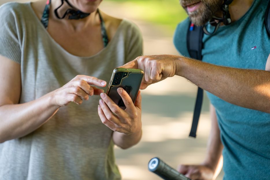 Zwei Personen schauen auf ein Handy