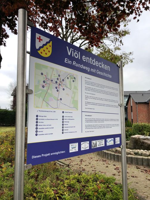 Schild mit allen Informationen zum Rundweg durch Viöl auf Hoch- und Plattdeutsch.