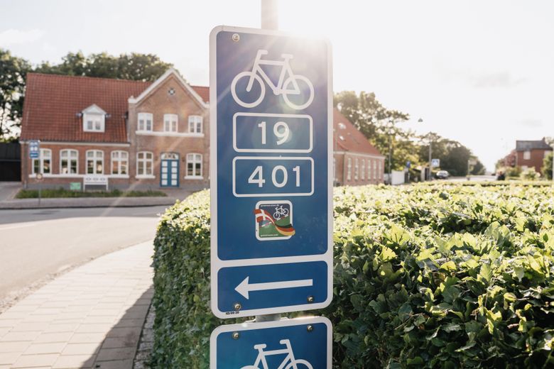 Schild mit Radwegen vor einem Haus