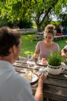ein Pärchen sitzt draußen am Tisch und isst Kuchen