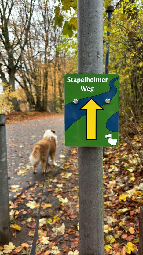 Schild Stapelholmer Weg mit Weg im Hintergrund