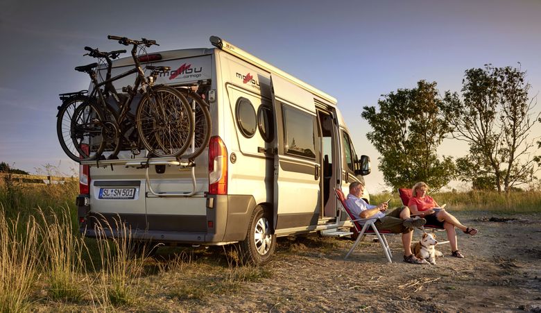 Pärchen mit Wohnmobil im Hintergrund