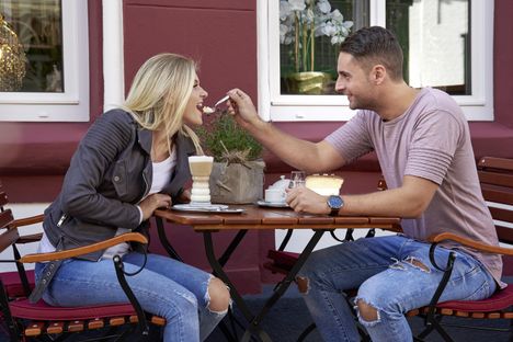Pärchen sitzt auf der Terrasse eines Cafés