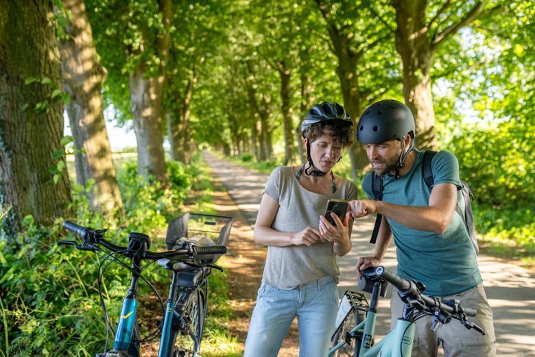 Radfahrer schauen auf das Handy für die beste Strecke