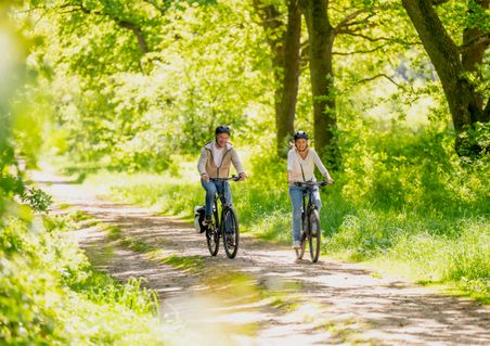 Pärchen fährt mit dem Rad einen Waldweg